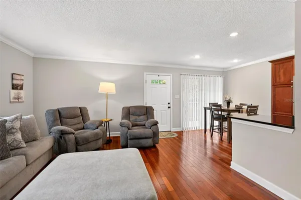 a living room with furniture and a wooden floor