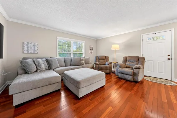 a living room with furniture and a wooden floor