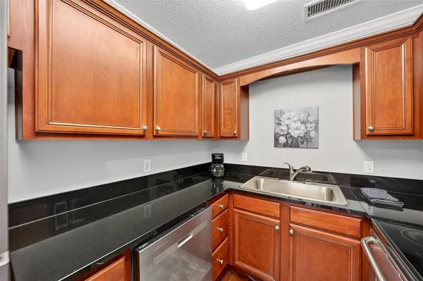 a kitchen with granite countertop cabinets and black appliances