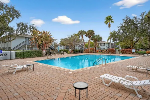 a view of a swimming pool with a lounge chair and a fire pit