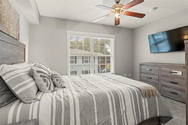 a bedroom with a large bed and a flat tv screen on dresser