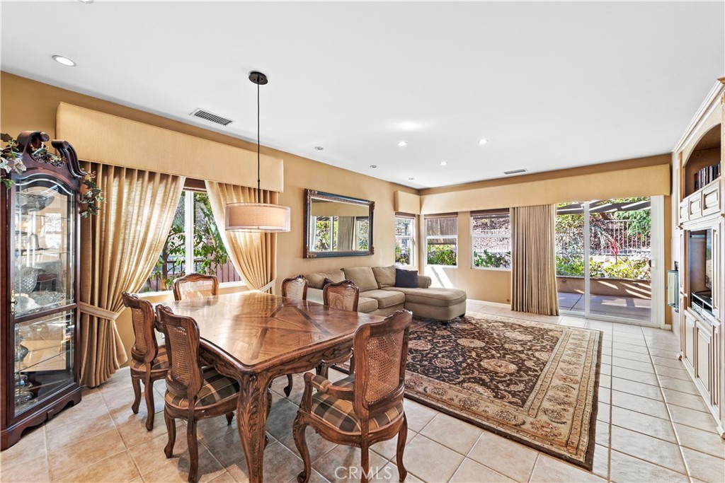 24575 Lowe Drive Corona, CA 92883 - Photo 11 of 44 a dining room with furniture wooden floor a rug a potted plant and a large window