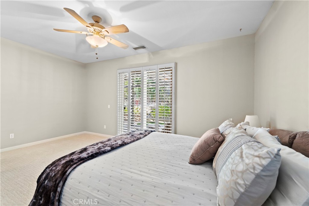 24575 Lowe Drive Corona, CA 92883 - Photo 16 of 44 a bedroom with a large bed and a chandelier