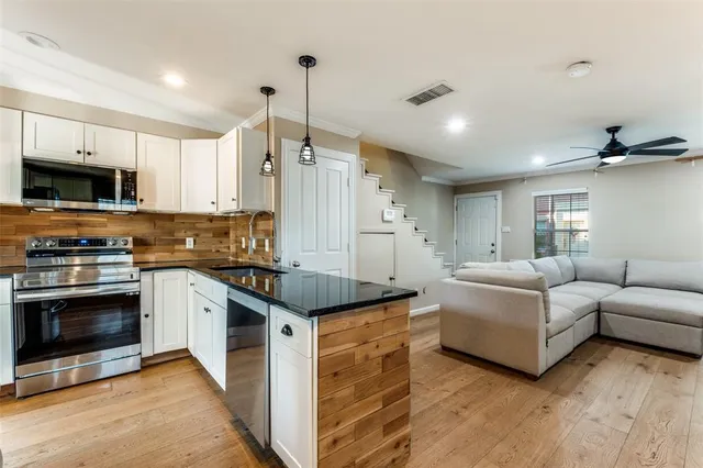 a kitchen with stainless steel appliances granite countertop a stove and a sink