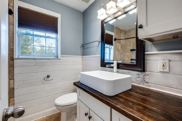 a bathroom with a sink a toilet and mirror
