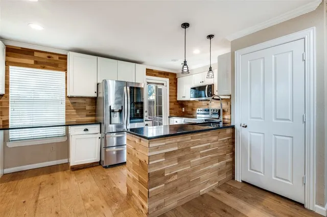 a kitchen with stainless steel appliances granite countertop a refrigerator a stove and a sink