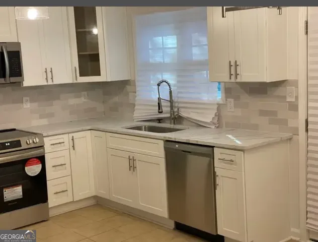 a kitchen with a sink cabinets and appliances