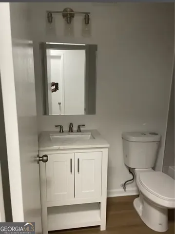 a bathroom with a toilet a sink and mirror