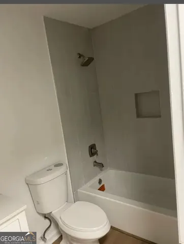a white toilet and tub sitting next to a bathroom sink