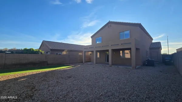 a view of a house with a yard and a large tree
