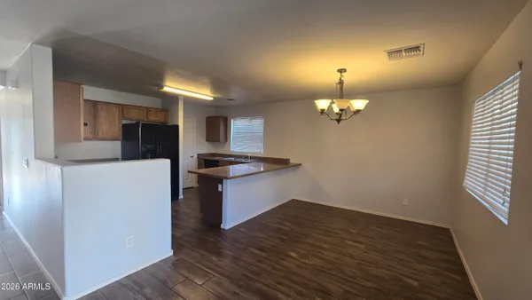a view of a kitchen with a sink wooden cabinets and a refrigerator