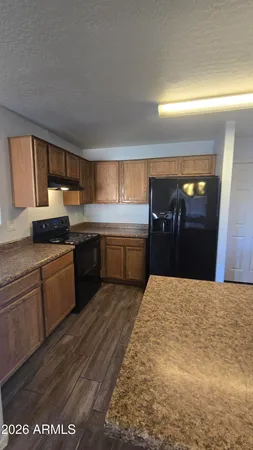 a kitchen with granite countertop a stove top oven and cabinets