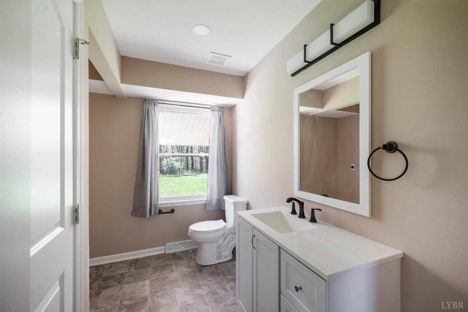 4070 Cottontown Road Forest, VA 24551 - Photo 17 of 38 a spacious bathroom with a toilet sink and mirror