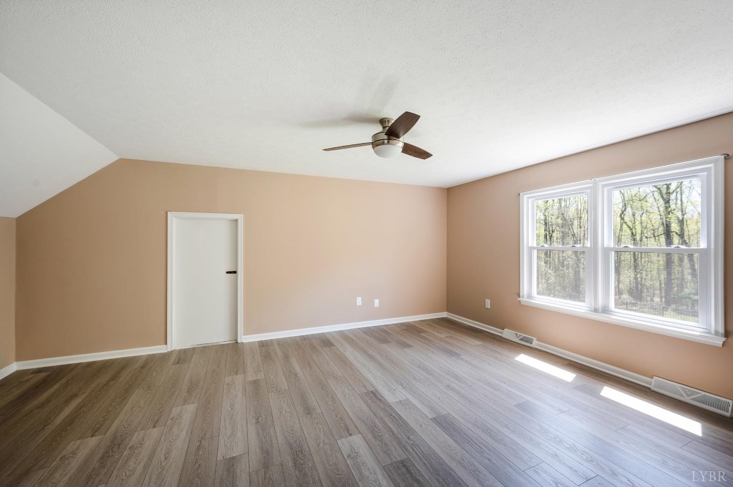 4070 Cottontown Road Forest, VA 24551 - Photo 25 of 38 a view of an empty room with wooden floor and a window