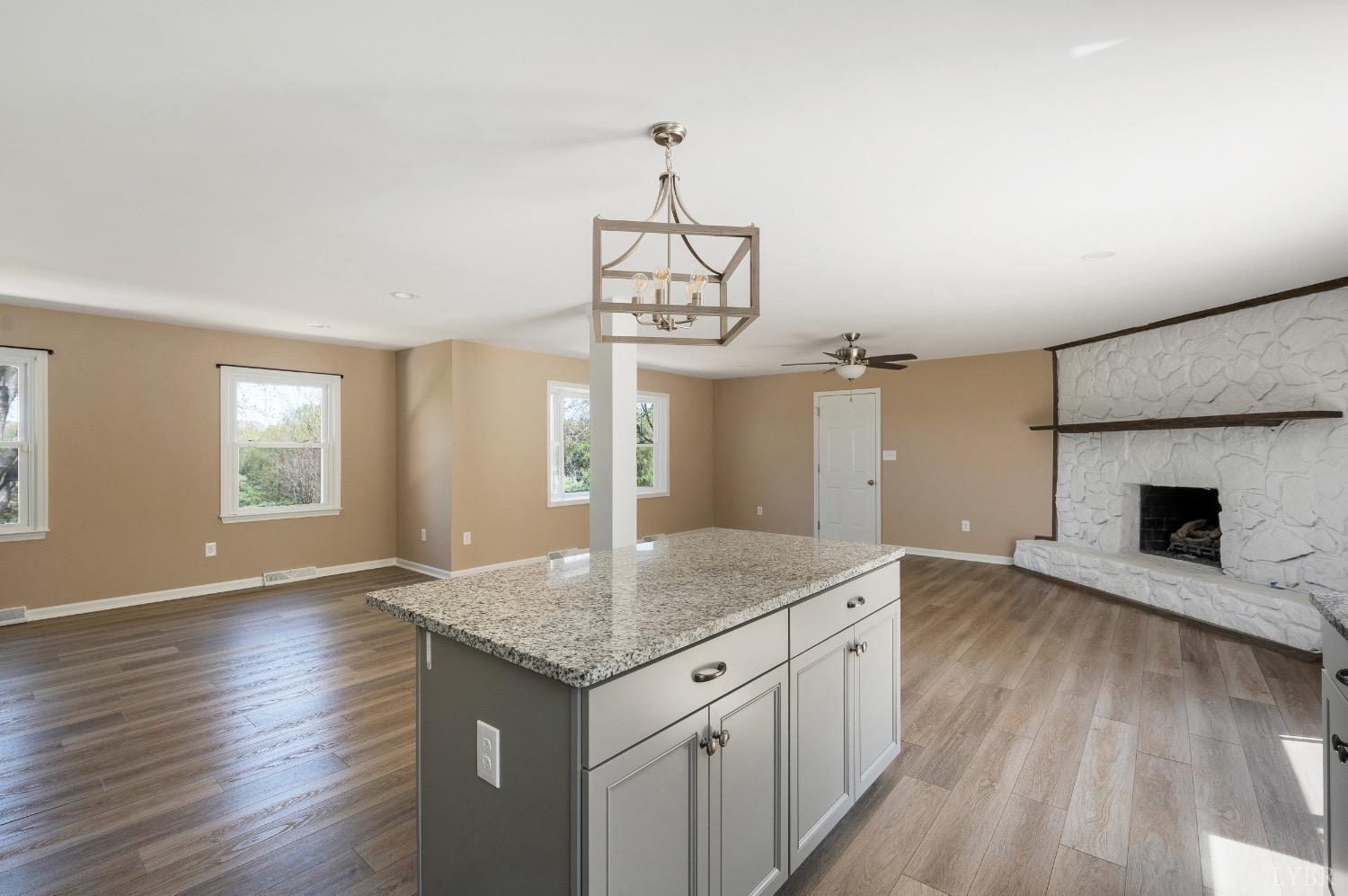 4070 Cottontown Road Forest, VA 24551 - Photo 7 of 38 an empty room with wooden floor and kitchen view