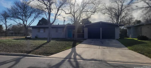 a front view of a house with a yard and a garage