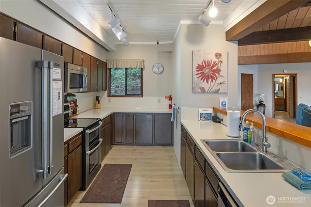 a room with stainless steel appliances kitchen island granite countertop furniture and a refrigerator