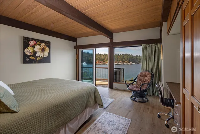 a bedroom with a bed and large windows