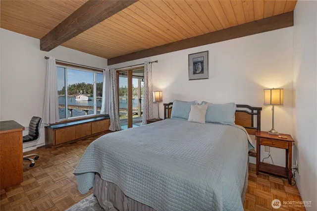 a spacious bedroom with a bed and wooden floor