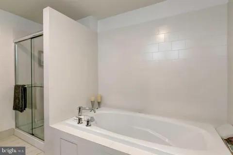 a white bath tub sitting next to a white sink and vanity