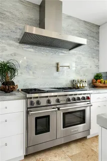 a stove top oven sitting inside of a kitchen
