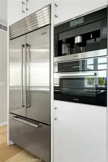 a living room with stainless steel appliances kitchen island granite countertop a sink a stove and a flat screen tv