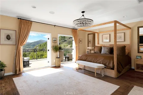 a bed sitting in front of a window next to a window