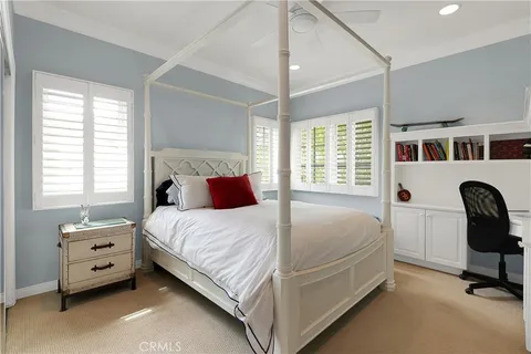 a bedroom with a bed and a flat tv screen on the dresser