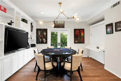 a dining room with wooden floor and chandelier