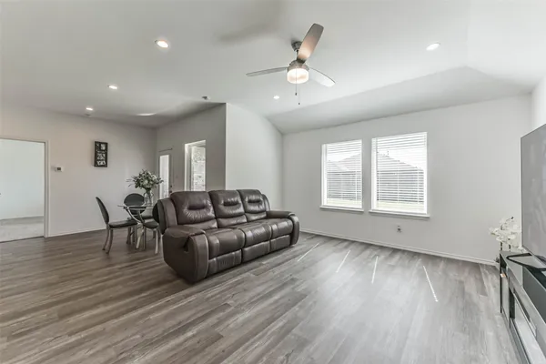 a living room with furniture and a wooden floor