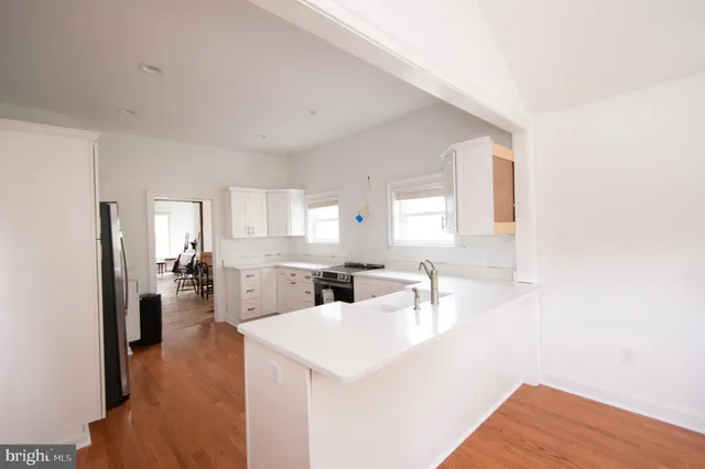 a view of a living room with furniture and wooden floor