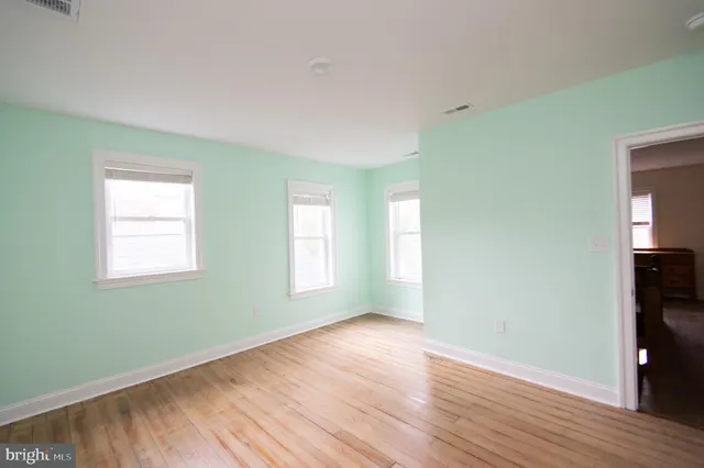 a white house that has tree in front of it