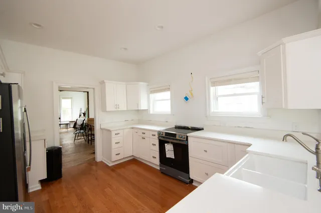 a kitchen with granite countertop stainless steel appliances a sink stove and cabinets