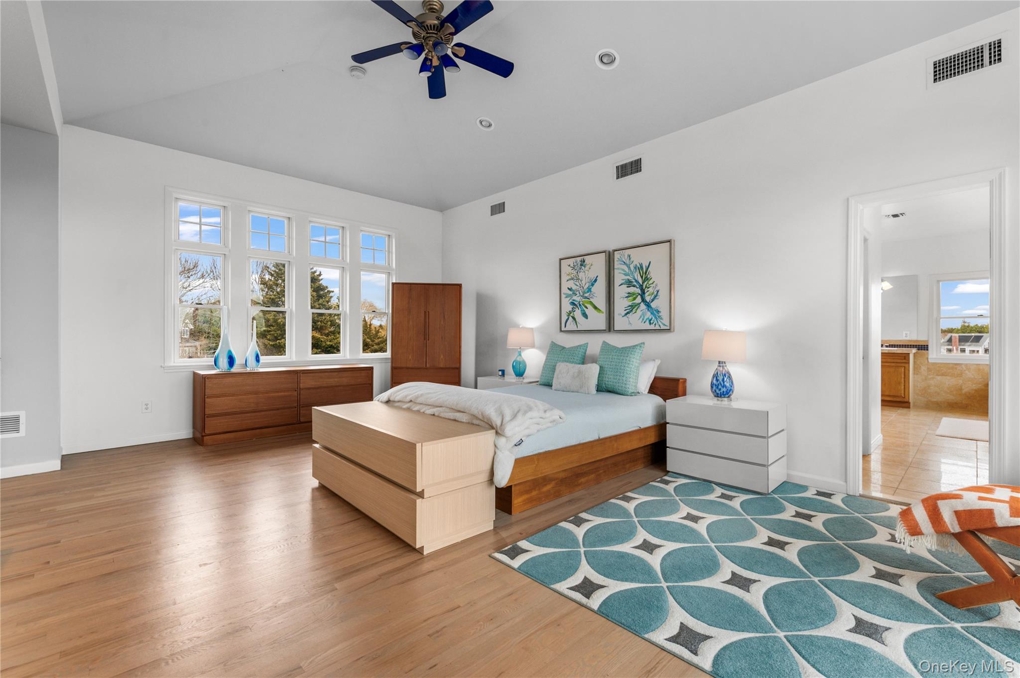 14 South Country Road Westhampton, NY 11977 - Photo 32 of 45 a bedroom with a large bed and a chandelier