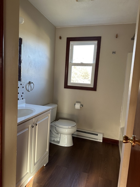 153-155 Arnold Avenue Springfield, MA 01119 - Photo 14 of 17 a bathroom with a toilet a sink wooden floor and window