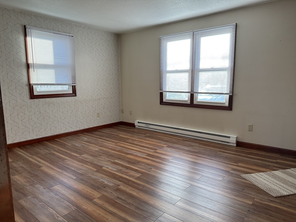 153-155 Arnold Avenue Springfield, MA 01119 - Photo 15 of 17 a view of an empty room with wooden floor and a window