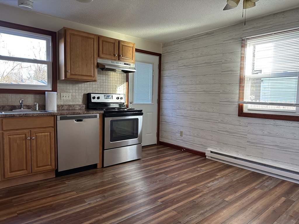 153-155 Arnold Avenue Springfield, MA 01119 - Photo 2 of 17 a kitchen with a wooden floor and a stove top oven