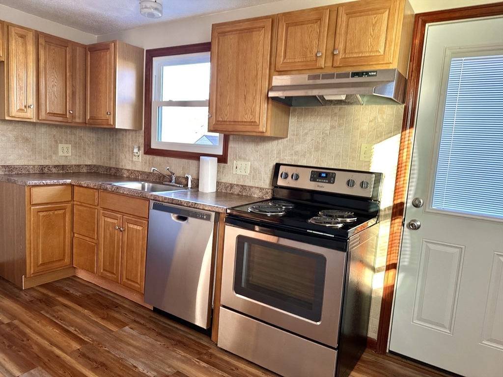 153-155 Arnold Avenue Springfield, MA 01119 - Photo 4 of 17 a kitchen with granite countertop wooden cabinets stainless steel appliances and a window