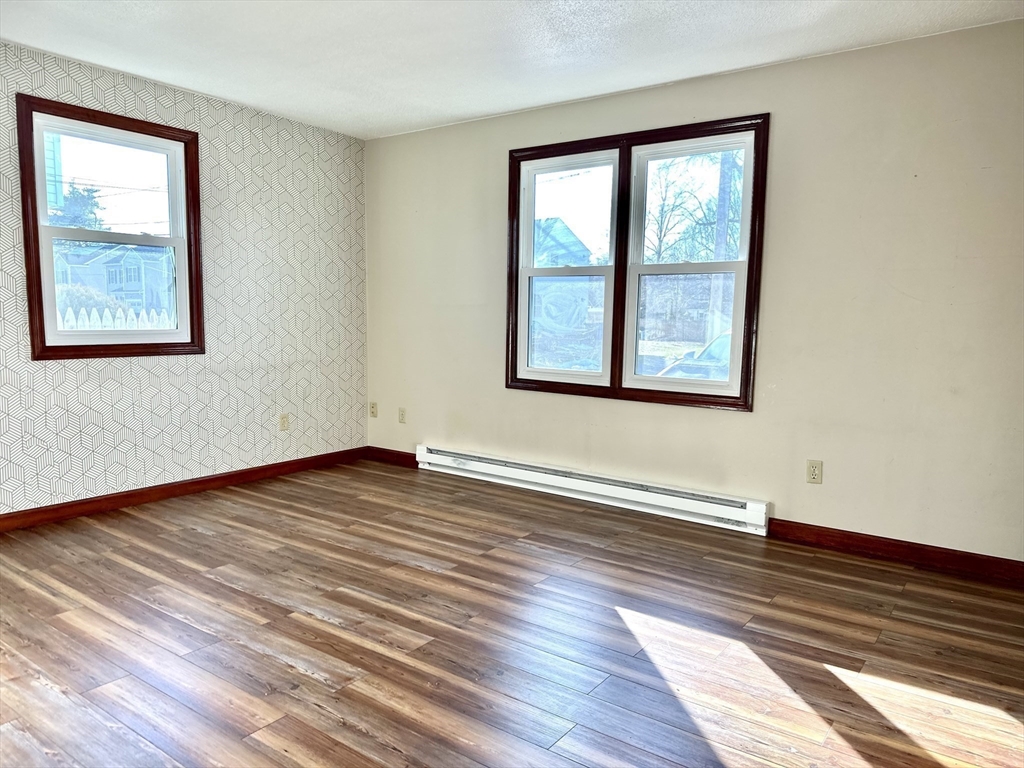 153-155 Arnold Avenue Springfield, MA 01119 - Photo 6 of 17 a view of an empty room with wooden floor and a window