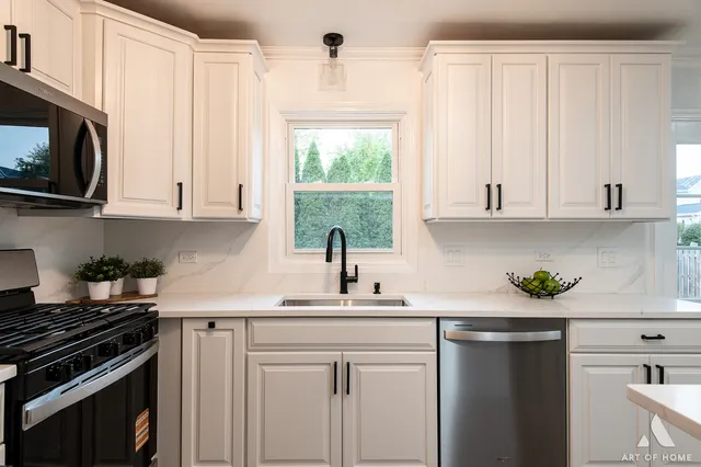 a kitchen with stainless steel appliances white cabinets and a stove top oven