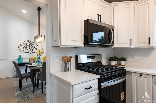 a kitchen with stainless steel appliances a stove a microwave a sink and cabinets