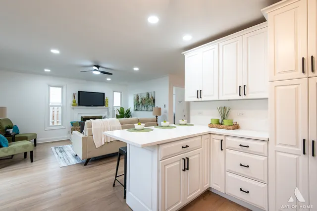 a kitchen with white cabinets and sink