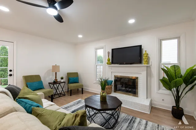 a living room with furniture a fireplace and a potted plant