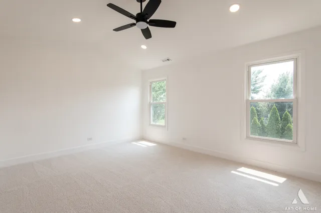 an empty room with windows and fan