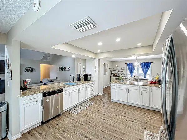 a large kitchen with stainless steel appliances kitchen island granite countertop a sink and cabinets