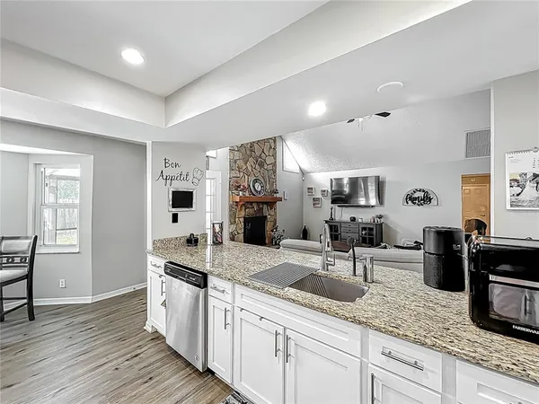 a kitchen with granite countertop a sink and cabinets