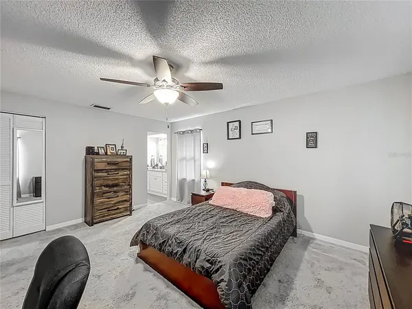 a bedroom with a bed a dresser and a chandelier