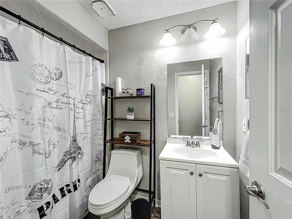 a bathroom with a sink a toilet and shower curtain