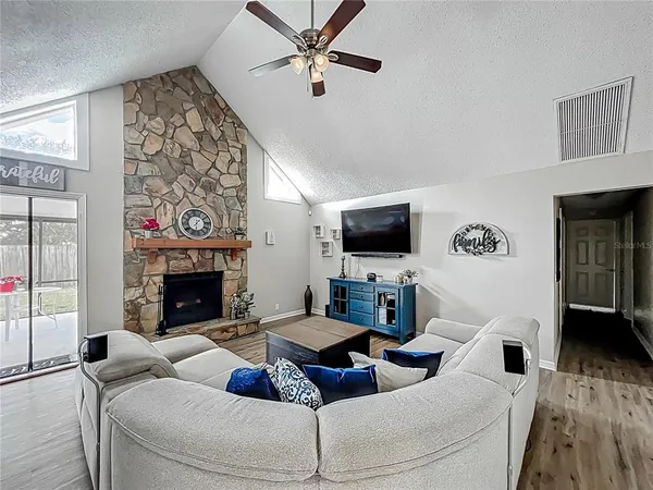 a living room with furniture a flat screen tv and a fireplace
