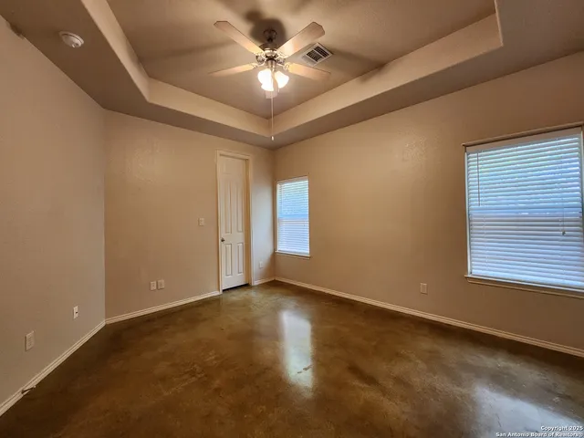 an empty room with windows and fan